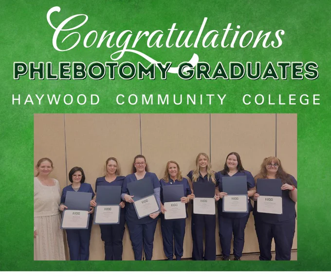 A group of people stand holding certificates in front of a banner that reads, "Congratulations Phlebotomy Graduates, Haywood Community College.
