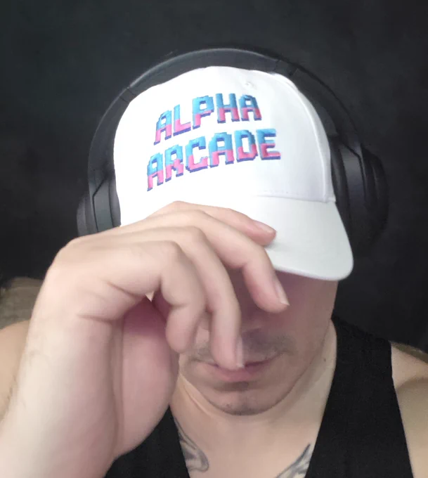 A handsome developer of alphaarcade showing off an exclusive hat only VIP people that has lost more than 2 million dollars in the platform gets as a prize.