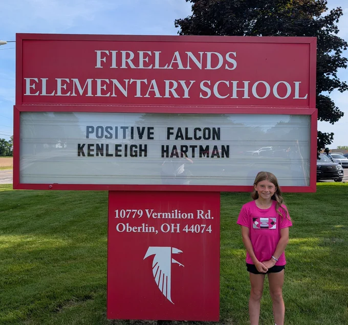 Student in front of sign 