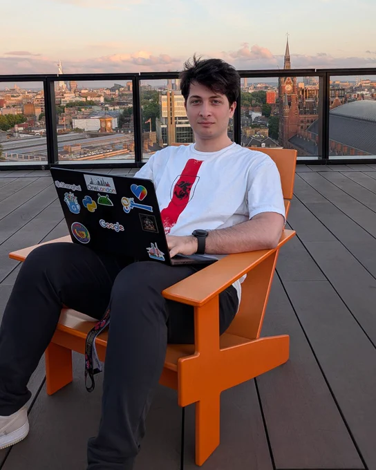 Irakli sitting outside in an orange chair. 