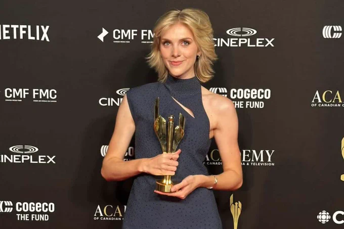 A woman standing on red carpet. 
