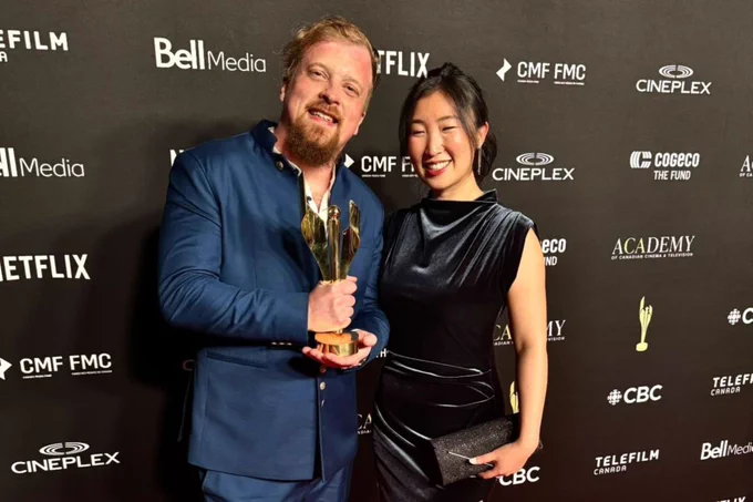 Man and woman standing on red carpet. 