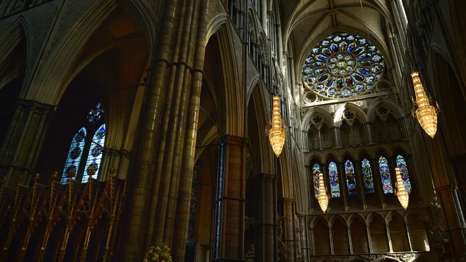 Early evening sunlight streaming into Westminster Abbey through a large rose window