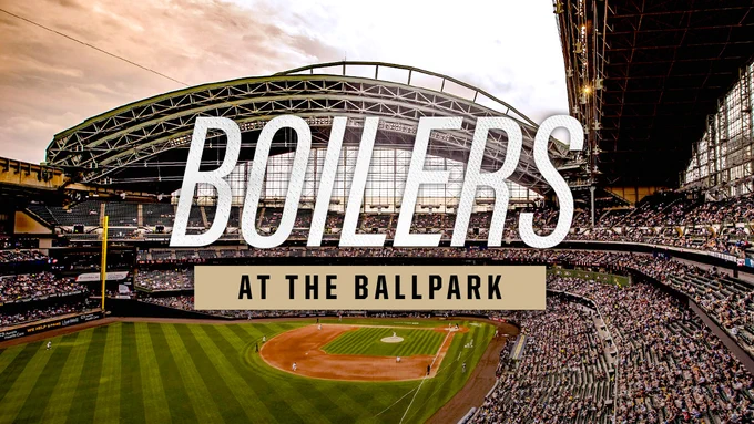 American Family Field baseball stadium with a partially open retractable roof, filled with a large crowd. Large text in the foreground reads “Boilers at the Ballpark.”