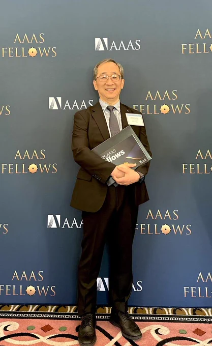 Dr. Dohun Pyeon stands in front of a backdrop reading "AAAS Fellows."