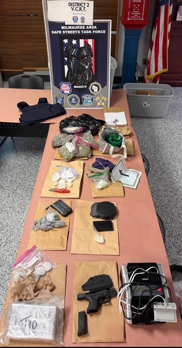 Photo of items on a table seized by the Milwaukee Area Safe Streets Task Force from search warrants recently included cocaine, fentanyl, a Glock firearm, body armor, and other illegal drugs.