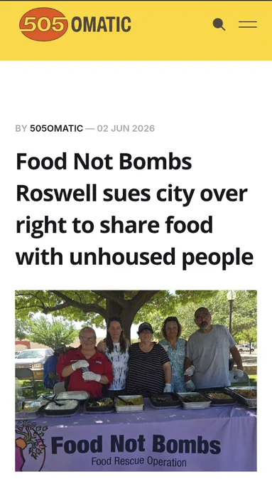 A screenshot of the 505OMATIC website showing a story with the headline "Food Not Bombs Roswell sues city over right to share food with unhoused people" and a photo of five people standing behind a table serving food.