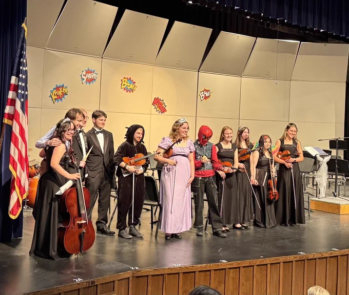 Senior orchestra students on stage for the princess and super hero event in May 2026.