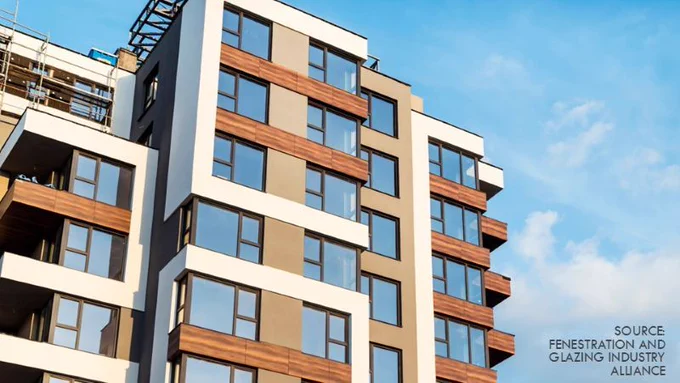 Photo shows modern multi-story residential building with large windows and mixed facade materials, illustrating typical fenestration systems.