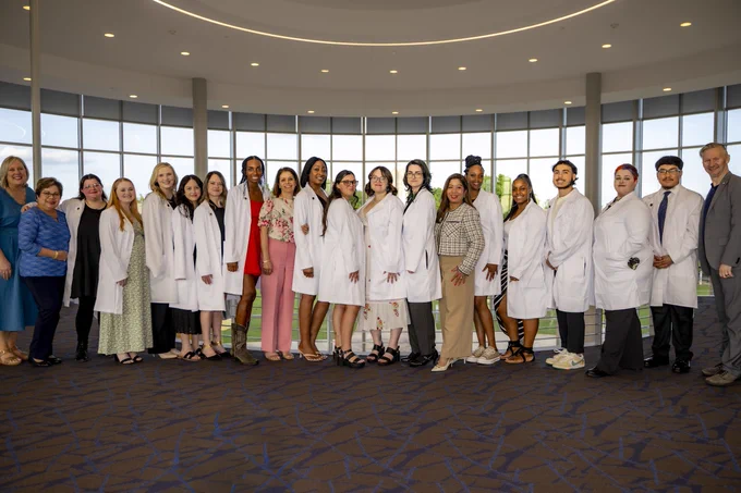 RSC MLT Class of 2026 takes a photo with their professors in the white coats.