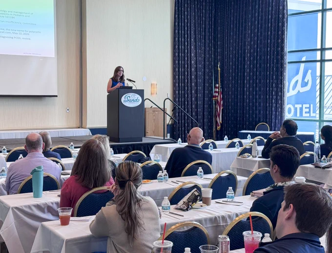Rep. McBride, pictured speaking from a podium, addresses attendees at a conference addressing the health and wellness of Delaware's children. 