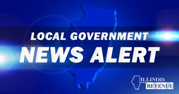 A graphic with a blue background shows a large outline of the state of Illinois in the center. Across the middle of the image, bold white text reads “Local Government News Alert.” Lens‑flare style light effects appear on the left and right sides. In the lower right corner is the Illinois Department of Revenue logo, which includes an outline of Illinois and the words “Illinois Revenue.