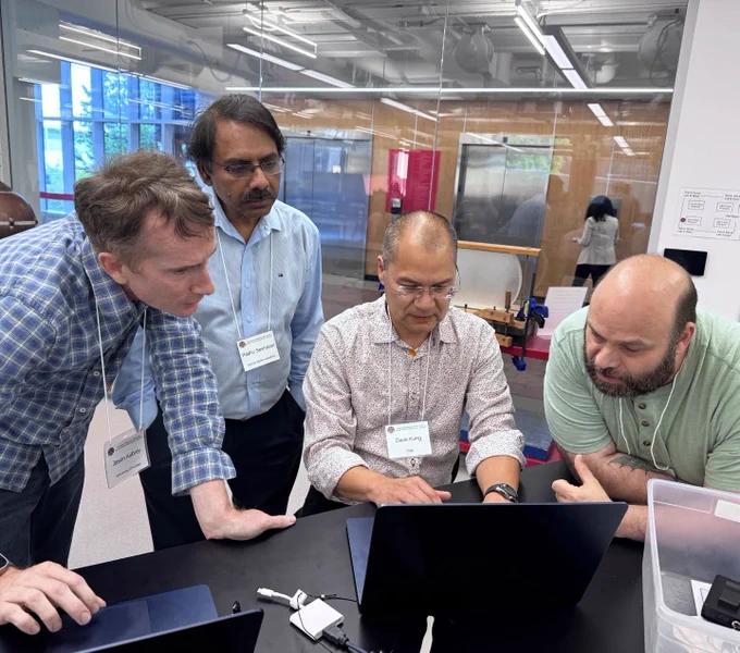 Four math educators huddled around a laptop.