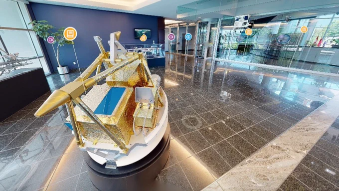 Detailed SCISAT model displayed in a modern, spacious showroom with reflective tiled floors and large windows.