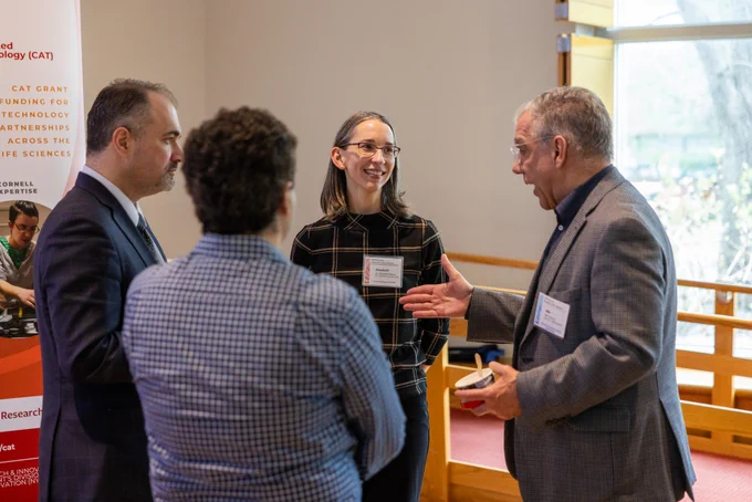 Attendees discuss with presenters in Biotech G10 of Cornell University