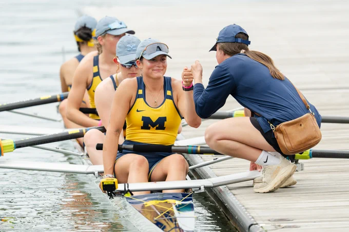 Grace Hammis fist-bumping Meagan Niehart from boat before NCAA Championships race