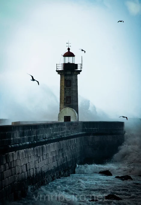 Farolim de Felgueiras na Foz do Douro, no Porto, com o mar a embater no molhe e o farol recortado contra o horizonte.