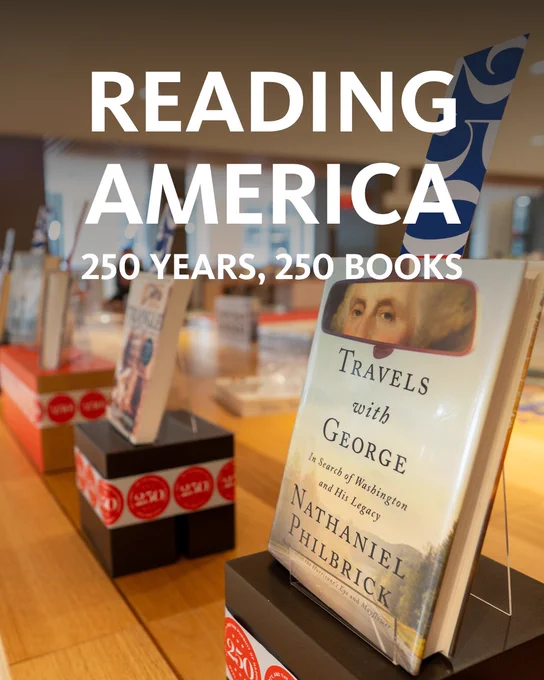 A display featuring the book "Travels with George: In Search of Washington and His Legacy" by Nathaniel Philbrick. The words "READING AMERICA, 250 YEARS, 250 BOOKS" appear above. Other books are blurred in the background.