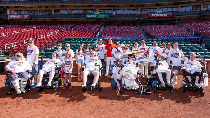Local families with the ALS Assocation pose for a photo with Michael McGreevy on the field at Busch Stadium.