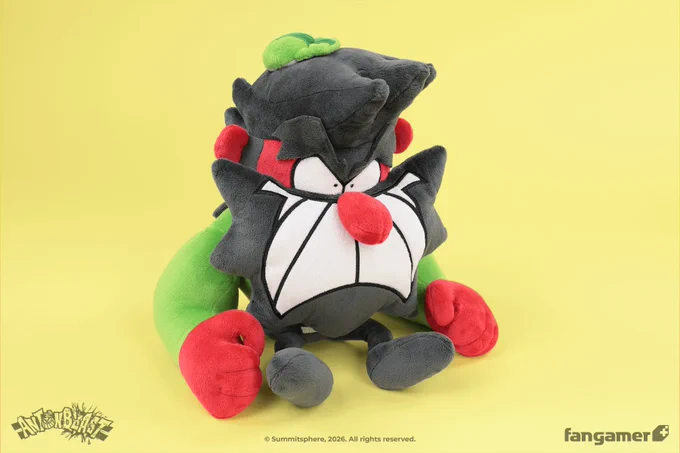 A photo of the Dynamite Anton plush against a yellow background, focused on its large arms and tiny legs. 