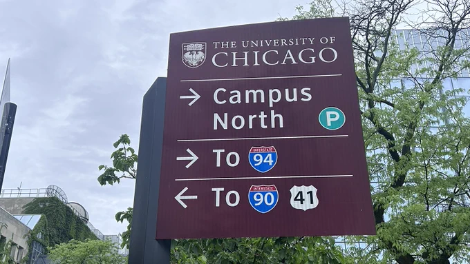 Sign for The University of Chicago. It reads: Campus North, with a 'P' symbol for parking; To Interstate 94, with a right arrow; To Interstate 90 and 41 with a left arrow.