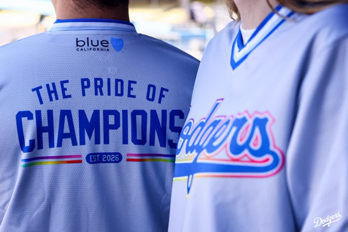 A photo of the Dodgers Pride jerseys. On the back of the jersey, it says, “The Pride of Champions” with the Blue California logo at the top of the jersey.