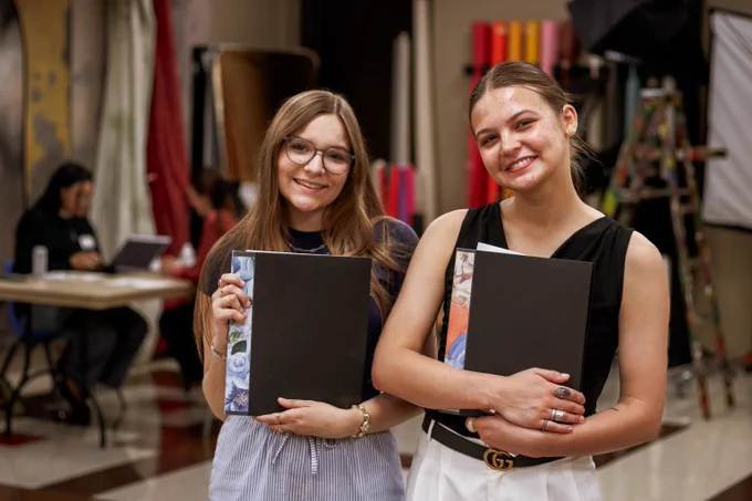 students pose with photo portfolios
