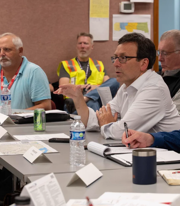 Bob speaking at table, seated next to other individuals