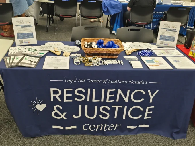 Table display for Legal Aid Center of Southern Nevada's Resiliency & Justice Center at UNLV with brochures, stress balls, and informational materials