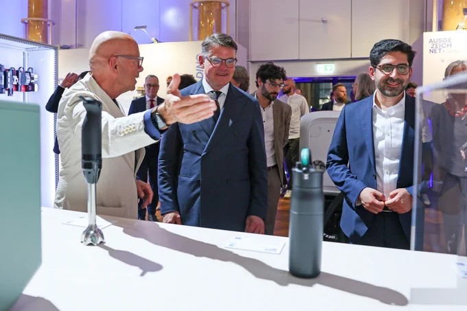 Eine Gruppe von mehreren Personen, darunter Männer in Anzügen, die eine Industrie-Ausstellung zu besuchen scheinen.