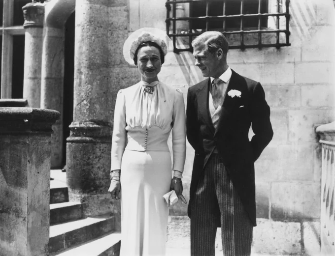 Wallis Simpson and Edward, Duke of Windsor, stand beside each other in a black and white phototgraph.