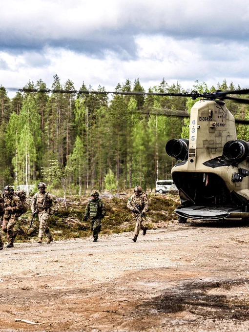 Des soldats descendent d’un hélicoptère Chinook lors d’un entraînement dans une forêt finlandaise.