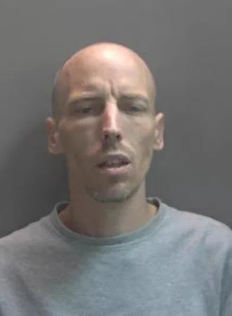 Bald white man wearing a grey sweatshirt