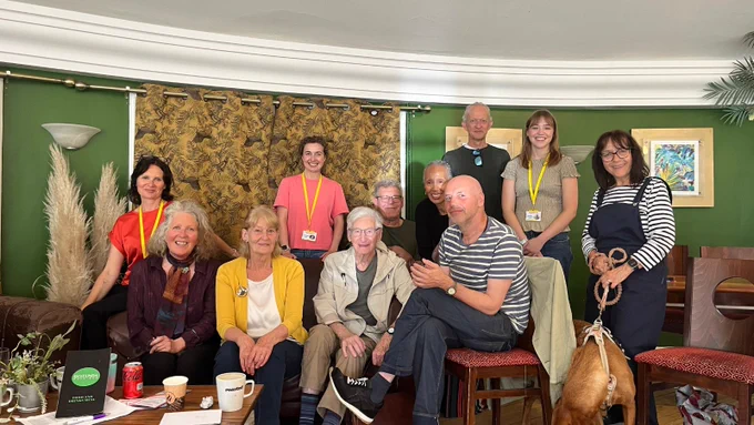 Some of our volunteers and our volunteer team sitting in the Rotunda in Preston Park and smiling at the camera