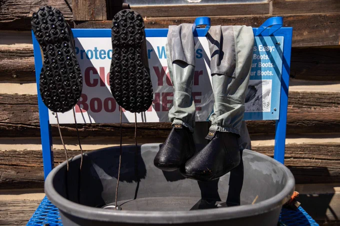 Waders and boots set out to dry at a gear cleaning station. 