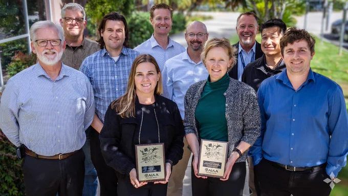 Group of General Atomics Aeronautical Systems employees standing outdoors holding framed awards