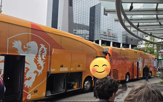 2 big orange player busses with a white lion on it