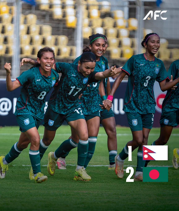 A group of female soccer players from Bangladesh celebrates energetically after a victory against Nepal. The mood is joyous and triumphant.
