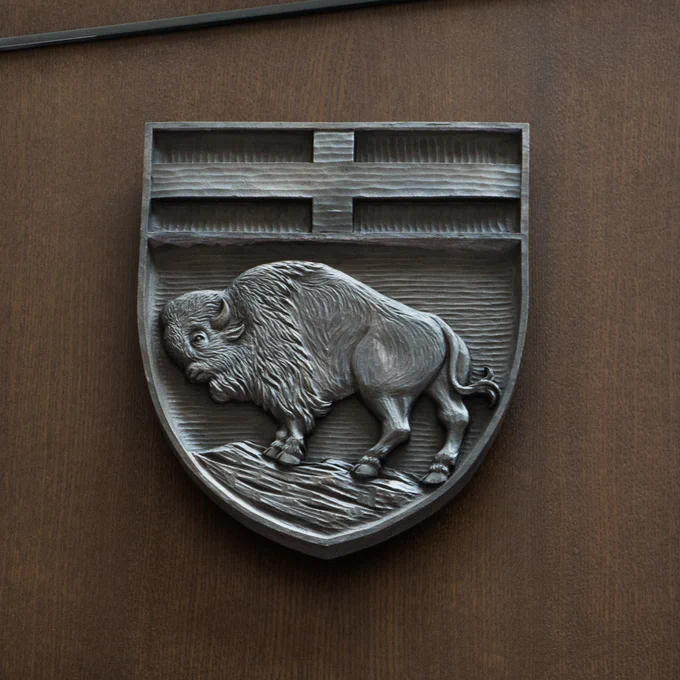 The coat of arms for the province of Manitoba, featuring the red cross of St. George  and a bison. 