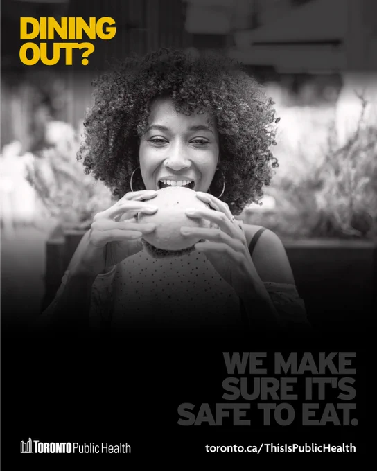 Black & white series of graphics with the Toronto Public Health logo & link to toronto.ca/ThisIsPublicHealth at the bottom of each image. This photo shows a woman taking a bite of a burger. Yellow text says, ‘Dining out?’ In faded text underneath we can read, ‘We make sure it’s safe to eat.’