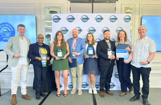 Eight people pose with awards