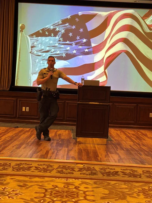 Captain Beza speaking to the audience at First Tuesday
