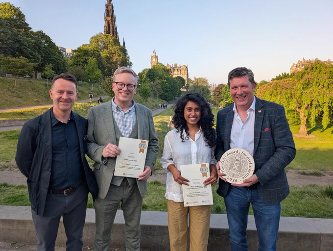 Four people holding awards, with the Scott Monument in Edinburgh in the background.