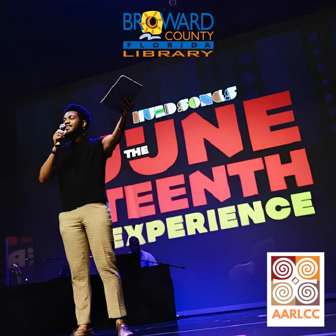 A performer on stage holding a microphone and a tablet, standing in front of a large screen that reads "Hued Songs - The Juneteenth Experience." The image features the Broward County Library logo at the top and the AARLCC logo in the bottom right corner.