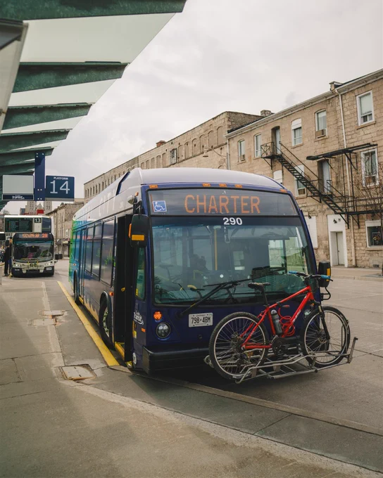 Guelph Transit bus with bike rack and red bicycle mounted on the front. 