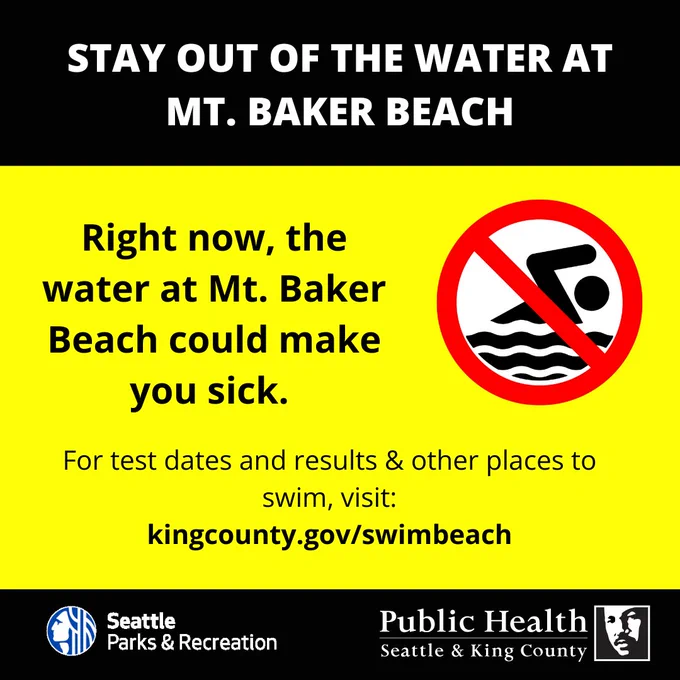 Warning sign advising to avoid swimming at Mt. Baker Beach due to water contamination risks.