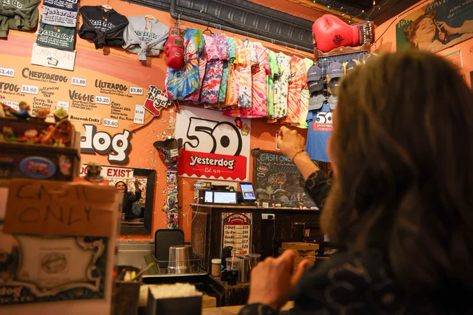 Gov. Whitmer throws coins in a bucket at Yesterdog.