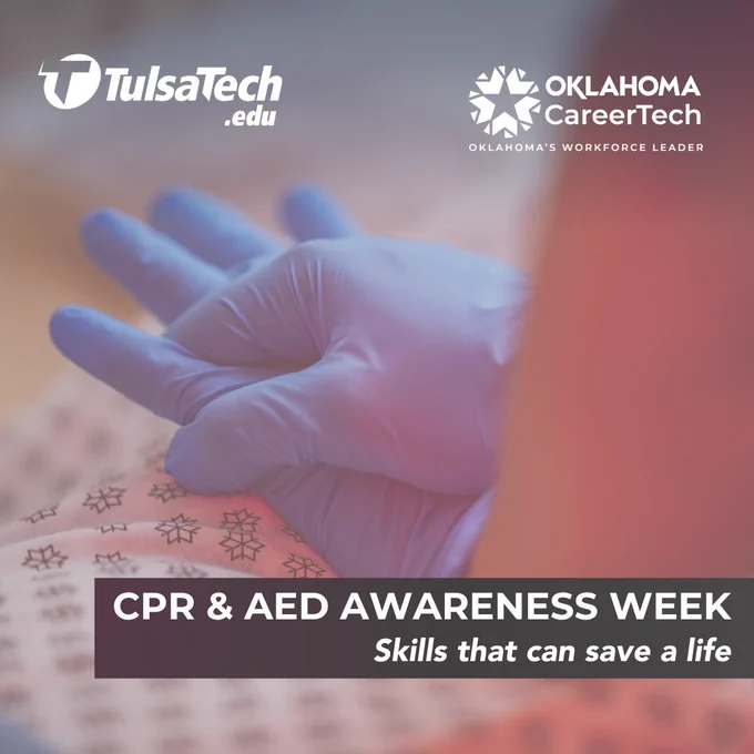 Close-up of a gloved hand performing CPR chest compressions on a training mannequin during awareness week.