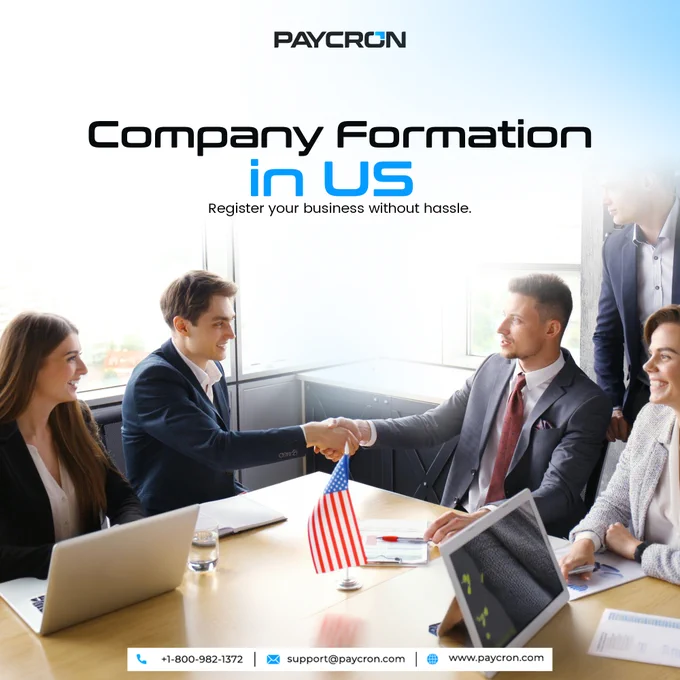 Paycron promotional banner featuring a group of business professionals in a meeting room, with two executives shaking hands across a conference table and a U.S. flag displayed in the foreground. The image highlights Paycron's U.S. company formation services, helping entrepreneurs and businesses register and establish their presence in the United States.