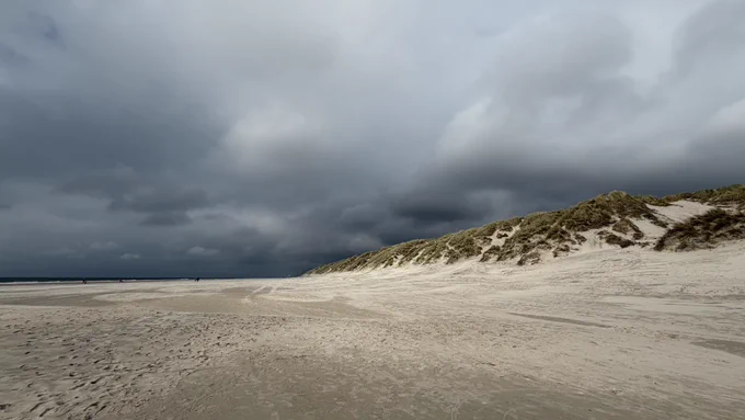 Strand und Dünen und ein bedrohlich dunkler Himmel